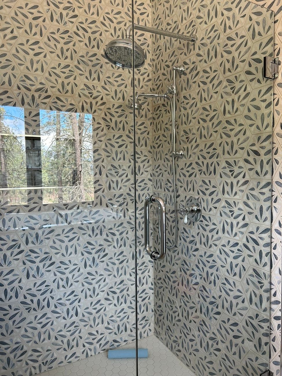 Frameless glass shower door on patterned tile